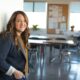woman in black coat standing by door at entrance to school classroom