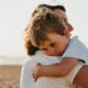 boy hugging woman during daytime