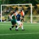 women playing soccer on green field during daytime