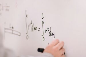person writing maths on a whiteboard
