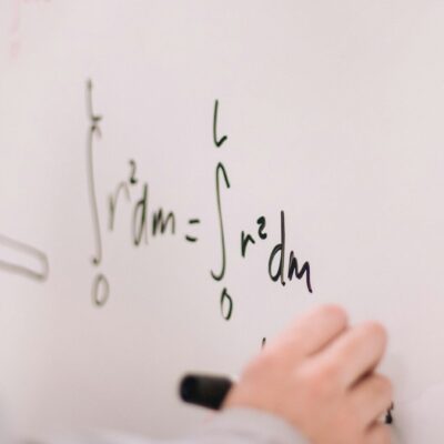 person writing maths on a whiteboard
