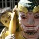 Child peeking from behind a colourful mask